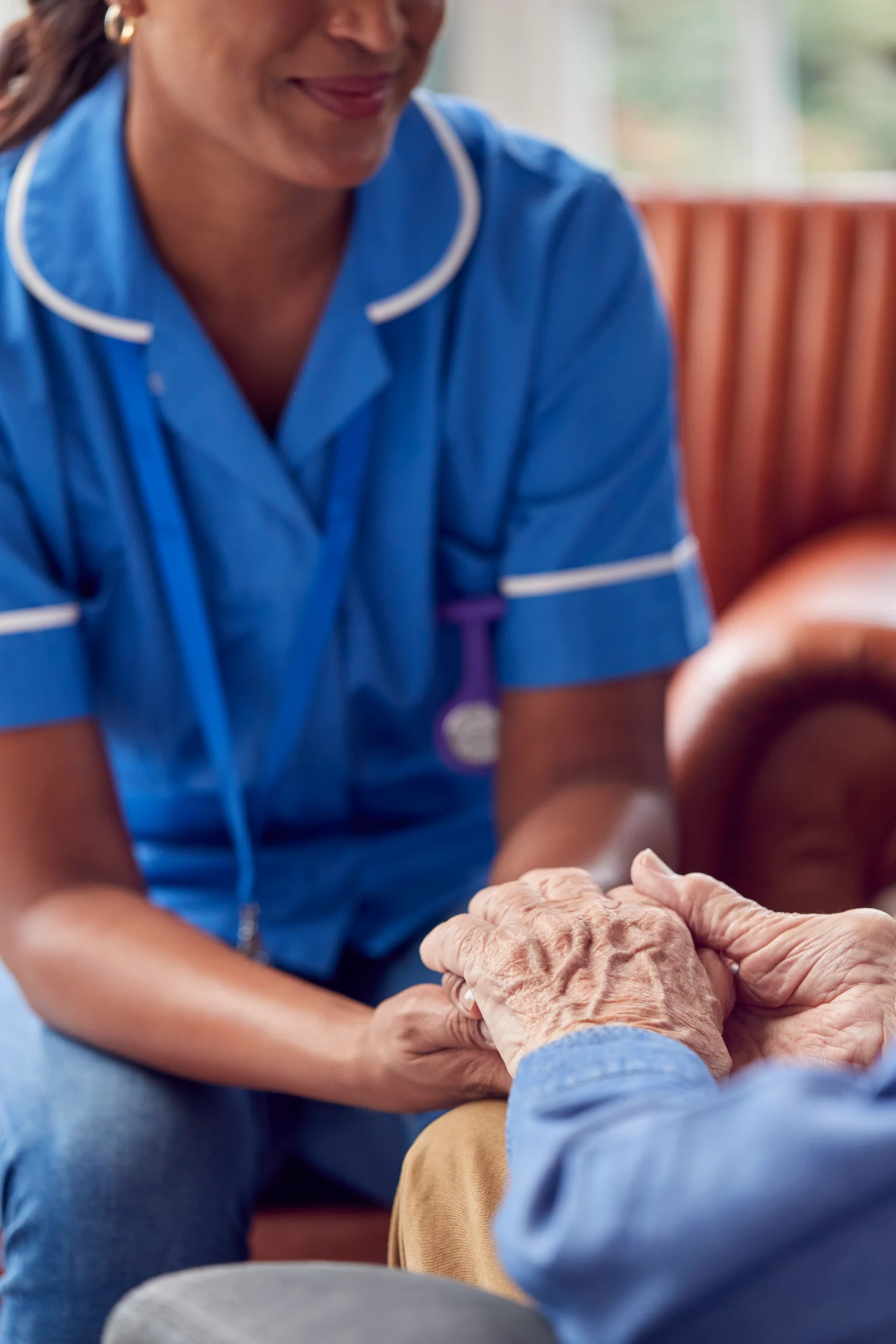 A care worker talking with an older man at home during a visit